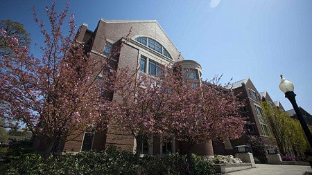 The University of Oregon School of Law building is shown against a cloudless sky. 