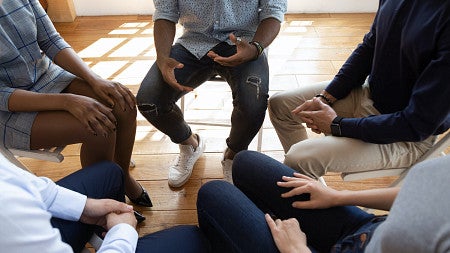 A group of people sit in a circle for a discussion