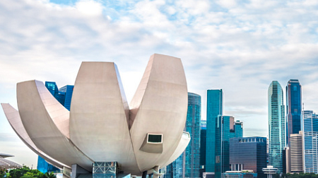 A building with lotus-flower-like architecture stands against a bright sky