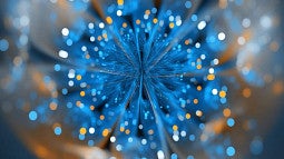 A blue and orange natural fractal is shown up close. Blue and orange feathers from the fractal's center while slightly blurry blue, orange, and white circles of light dance around the fractal's perimeter.