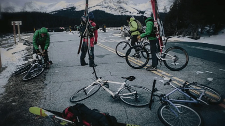 A group of cyclists stop to prepare for a ski trip