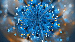 A blue and orange natural fractal is shown up close. Blue and orange feathers from the fractal's center while slightly blurry blue, orange, and white circles of light dance around the fractal's perimeter.