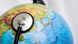 A stethoscope pressed against a globe