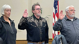 Susan Cobb, Michael Preedin, and Gary Ross raise their right hands as they are sworn in to new terms as Sisters City Councilors. 