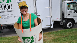 A costumed person smiles for the camera as they encourage donations to the annual food drive