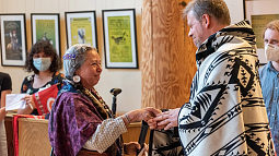 Collaborators shake hands as they meet in the Many Nations Longhouse