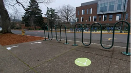New parking design on campus designates specific e-scooter parking spaces in neon green 