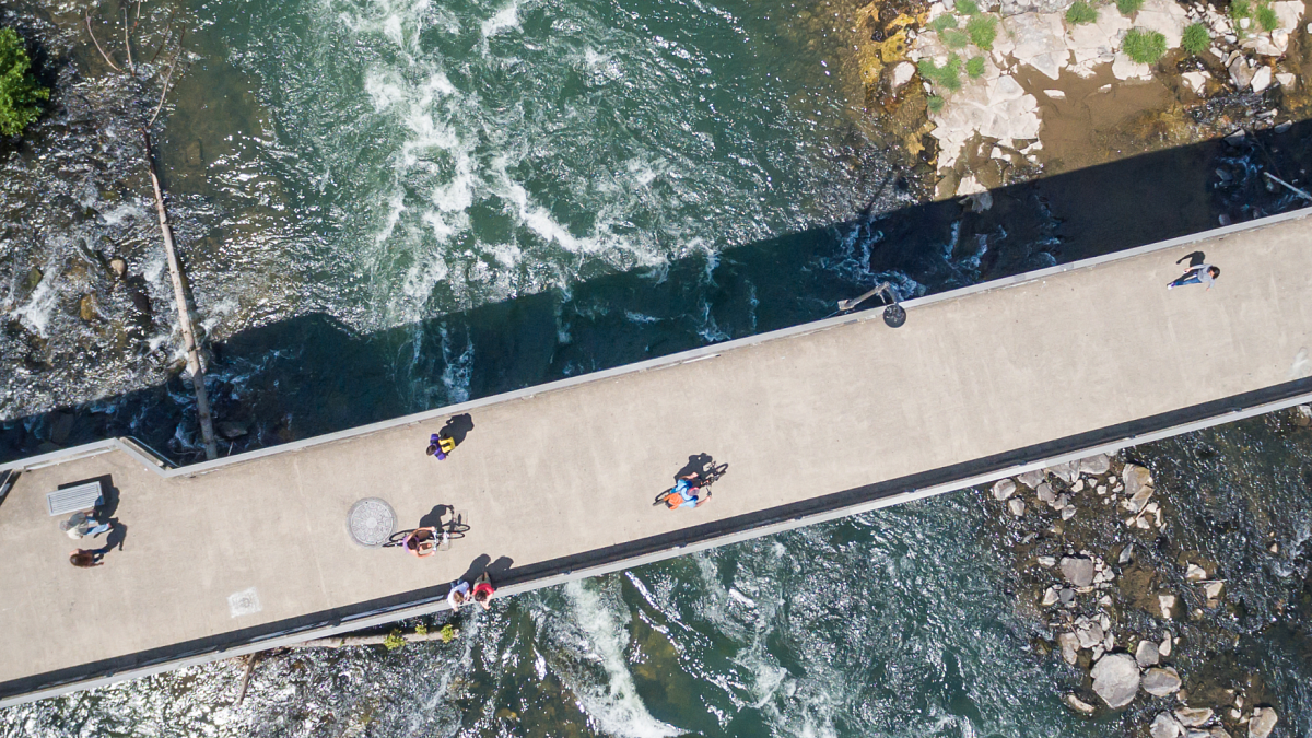 Cyclists and pedestrians traverse a bridge over the Willamette River